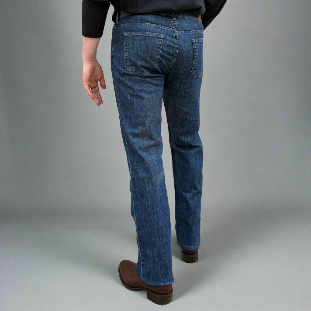 Close-up of dark wash stretch denim showing stitching, pocket edge and YKK zipper fly.