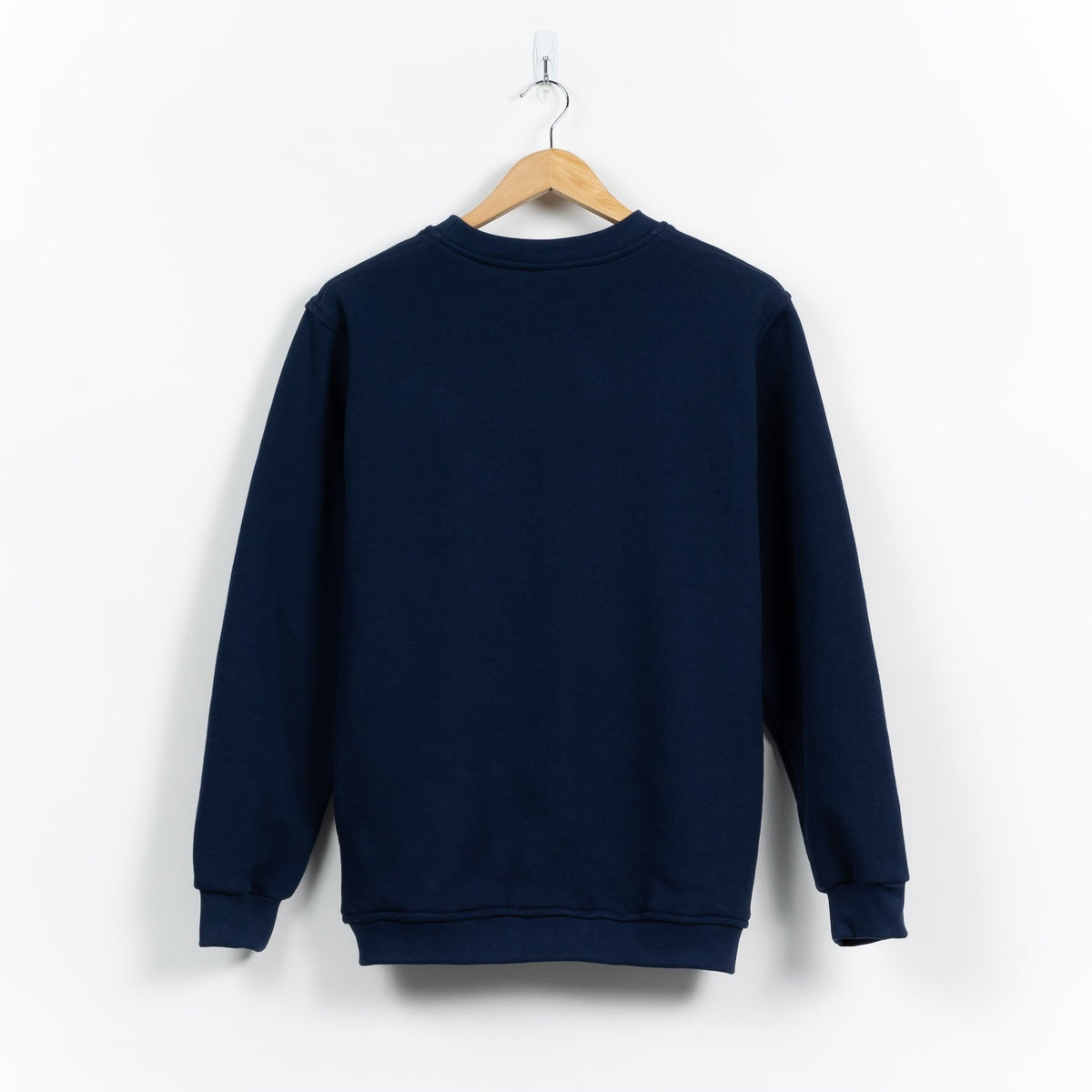 Man wearing the navy collegiate sweatshirt, showing the roomy chest and classic cut.