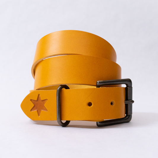 Olive squash leather belt coiled flat, showing the solid brass buckle in an antique brass finish.