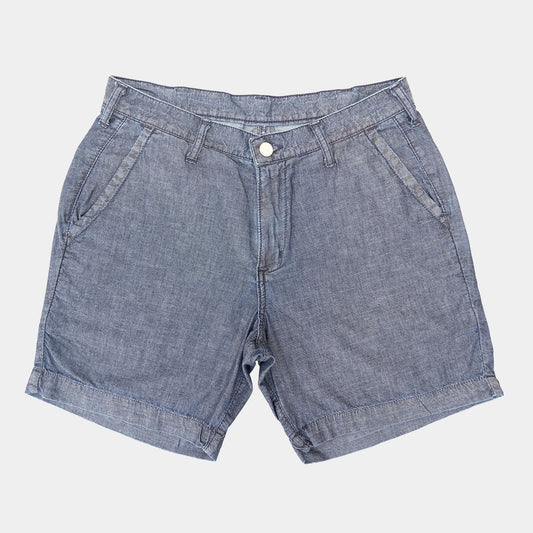Light blue chambray shorts laid flat, front view with belt loops and two front pockets
