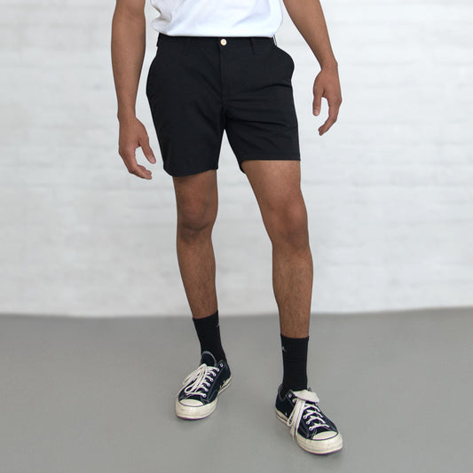 Black Tailored Technical Shorts laid flat, front view, showing 7 inch inseam and front pockets.