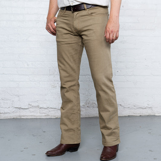 Khaki boot cut stretch jeans shown flat from the front with five-pocket styling and gold leaf button.